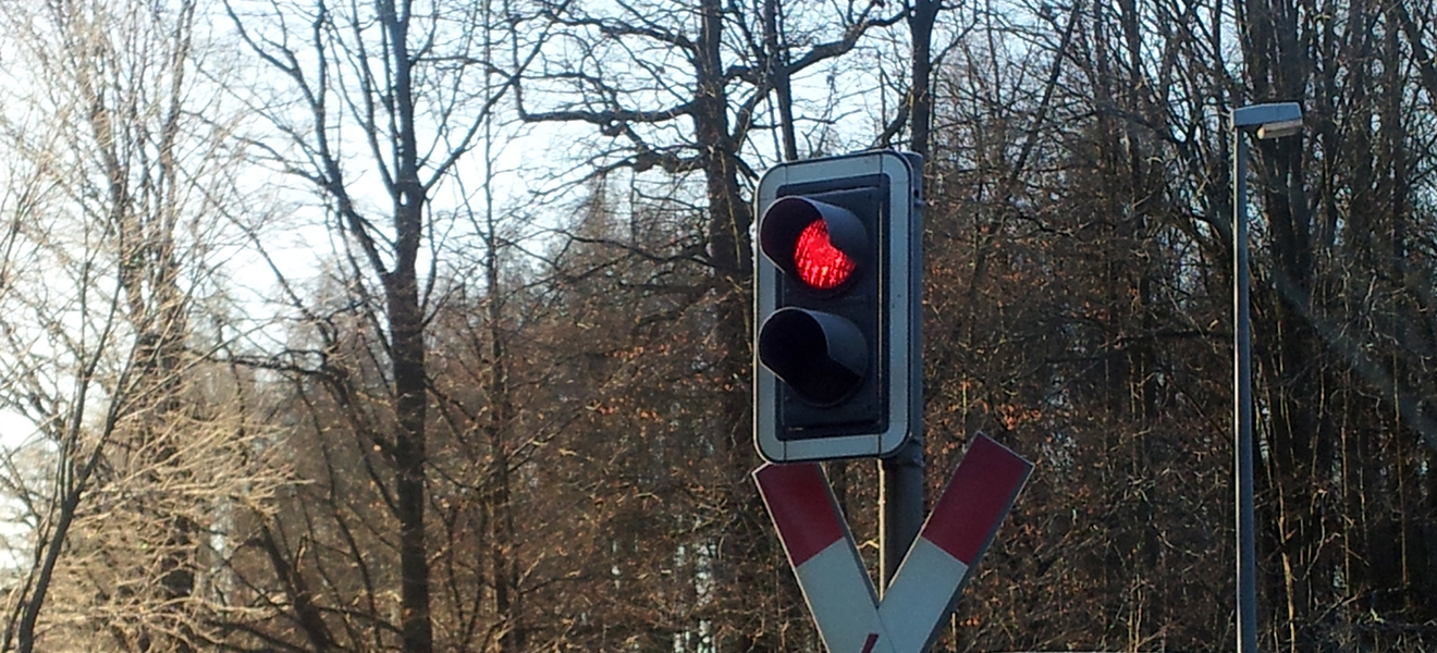 Andreaskreuz und Bahnübergangsleuchte auf rot
