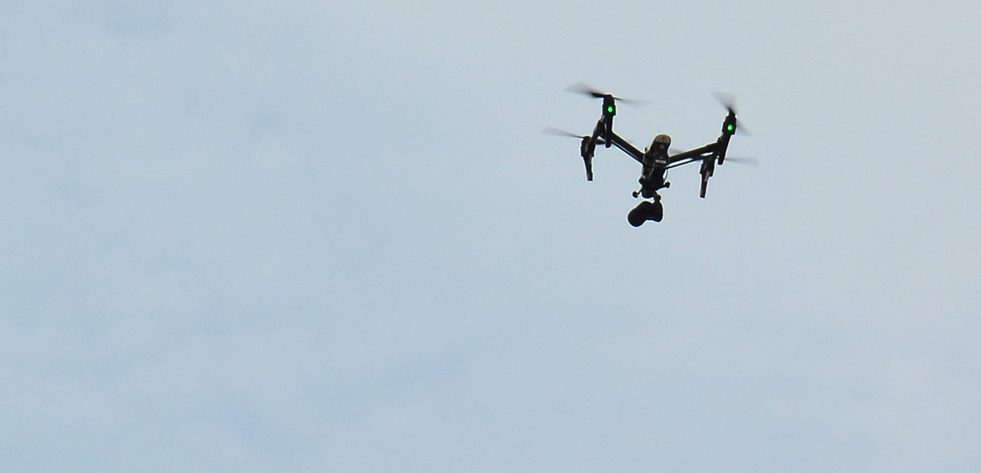 Eine Kamera-Drohne fliegt am Himmel.